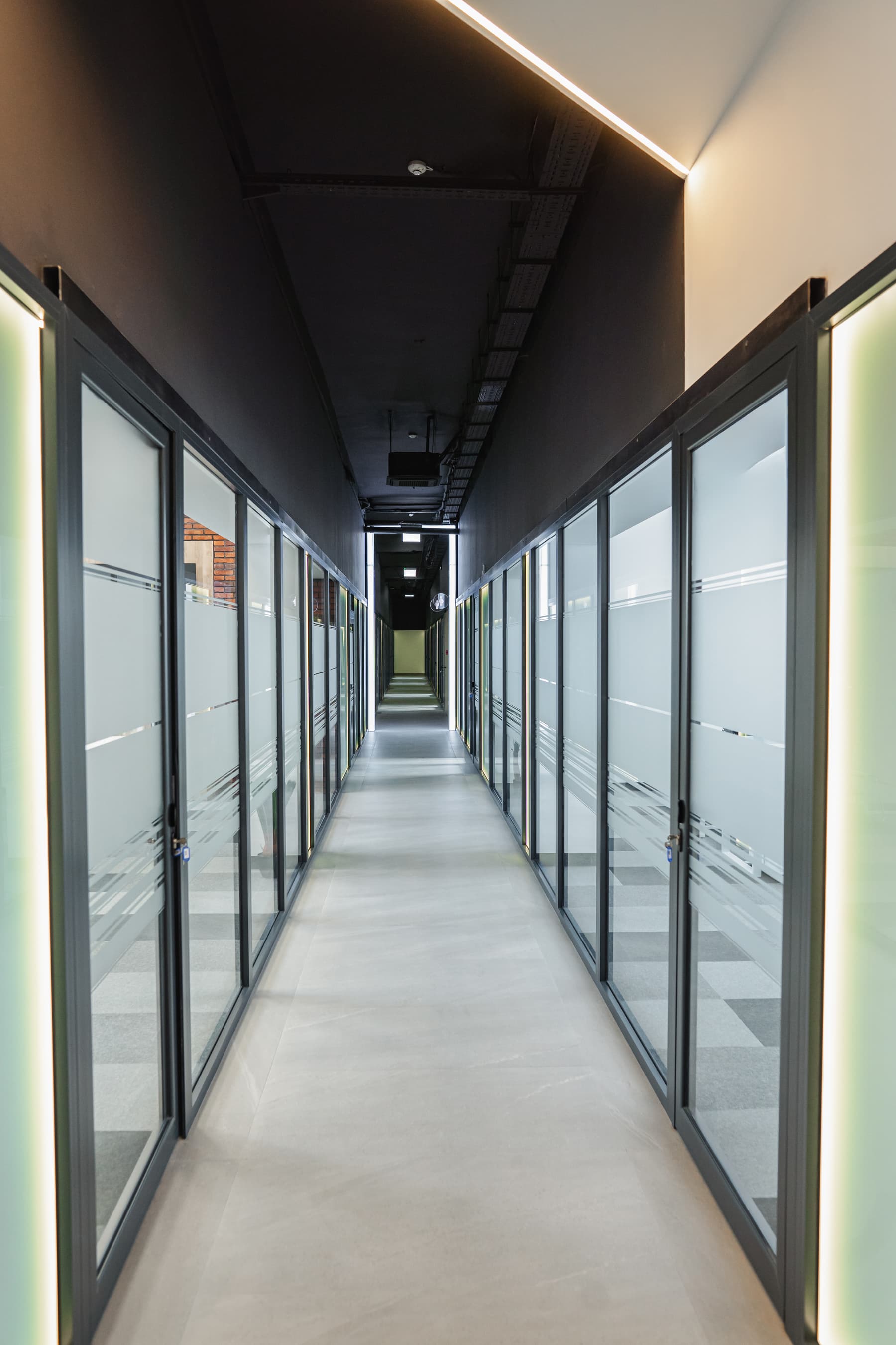 Long hallway lined with glass doors inside an office building