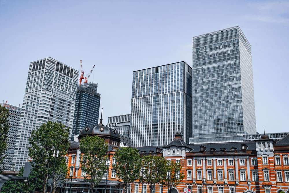 The red-brick Tokyo Station building in front of modern glass office towers in Marunouchi