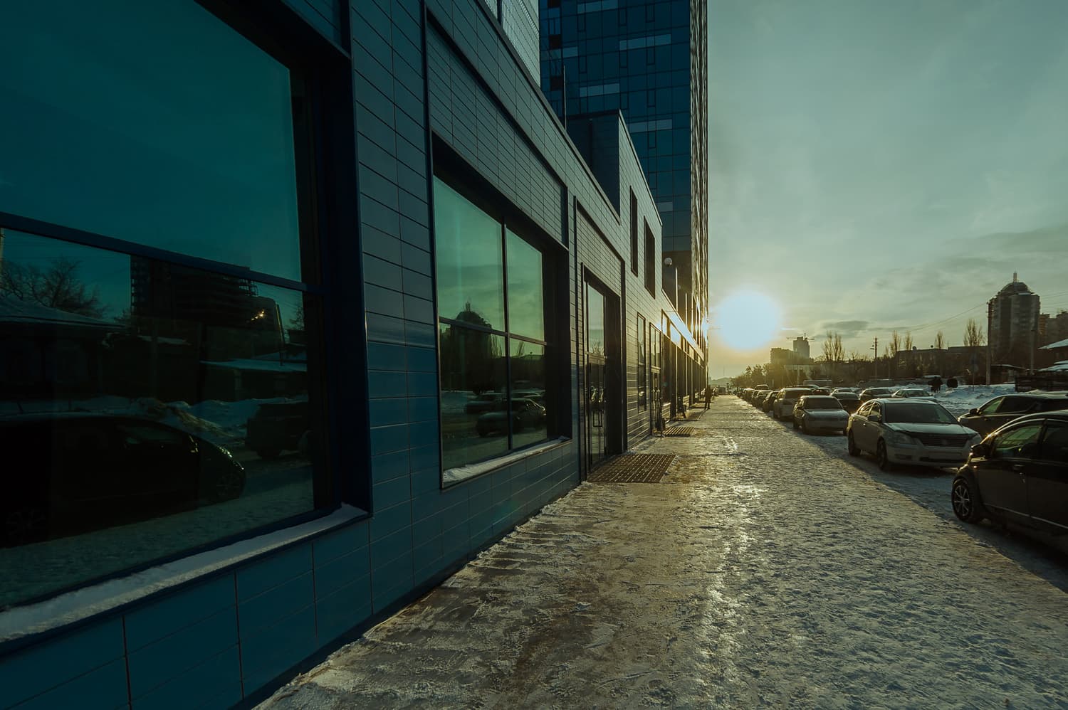 Cars moving along a city street at sunset