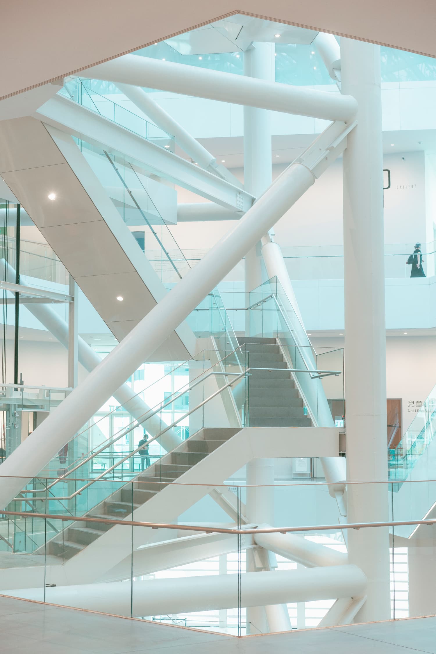 Steel and glass atrium with a staircase inside a modern building