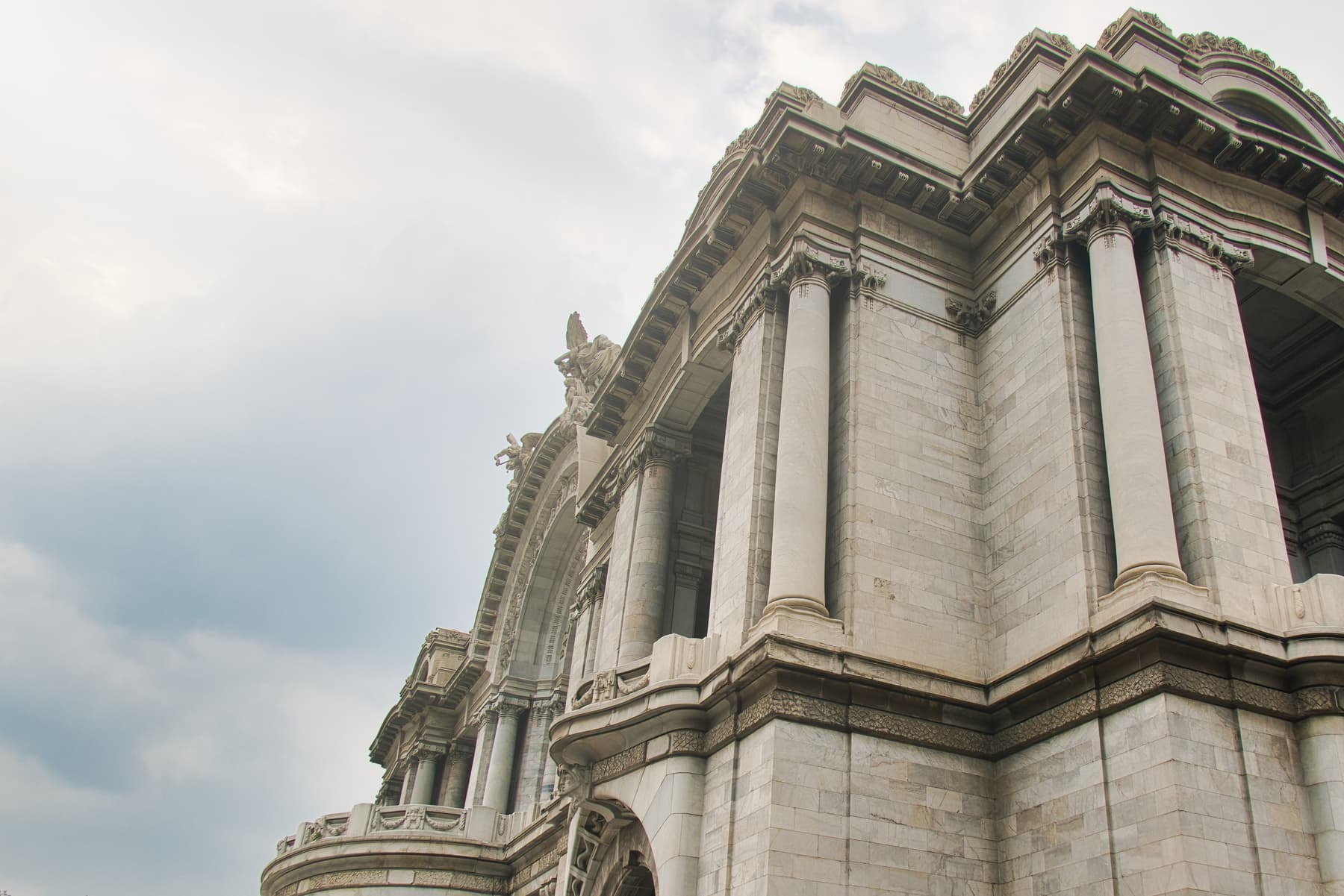 Ornate carved stonework on the upper facade of a Beaux-Arts building