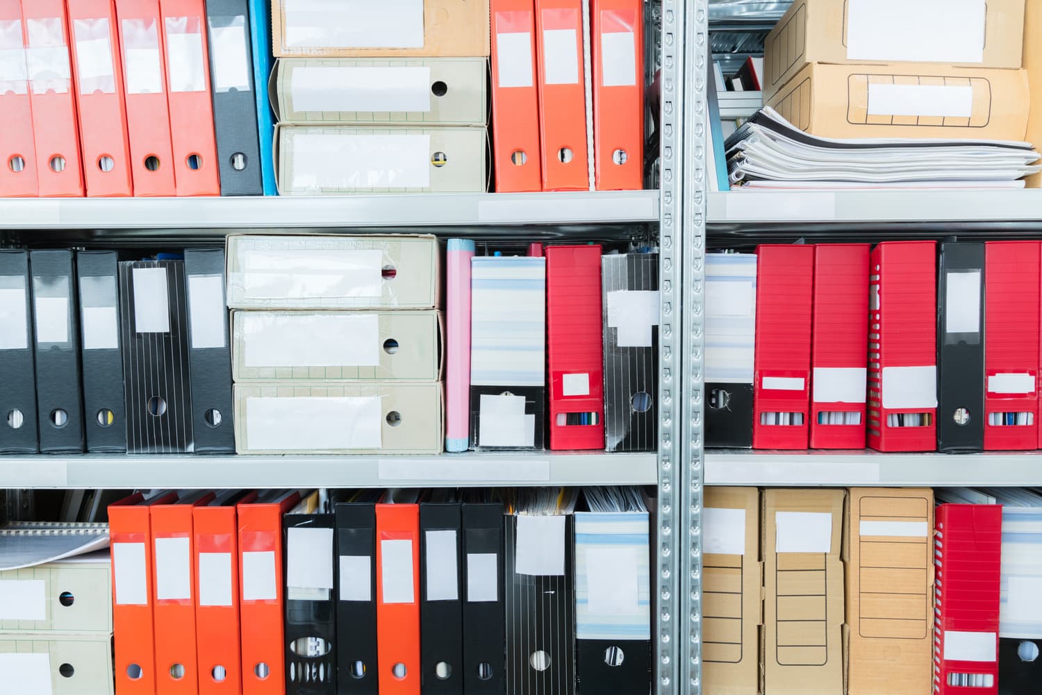 Colour-coded file folders lined up on a shelf