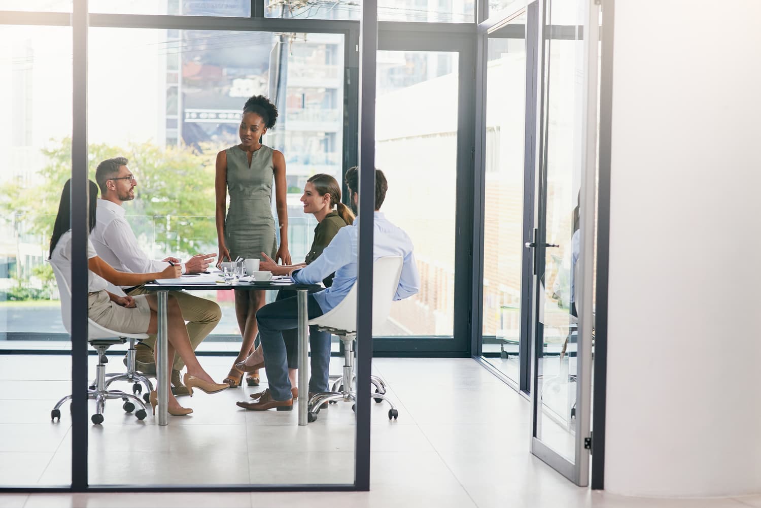 Group of colleagues in a boardroom meeting around a long table