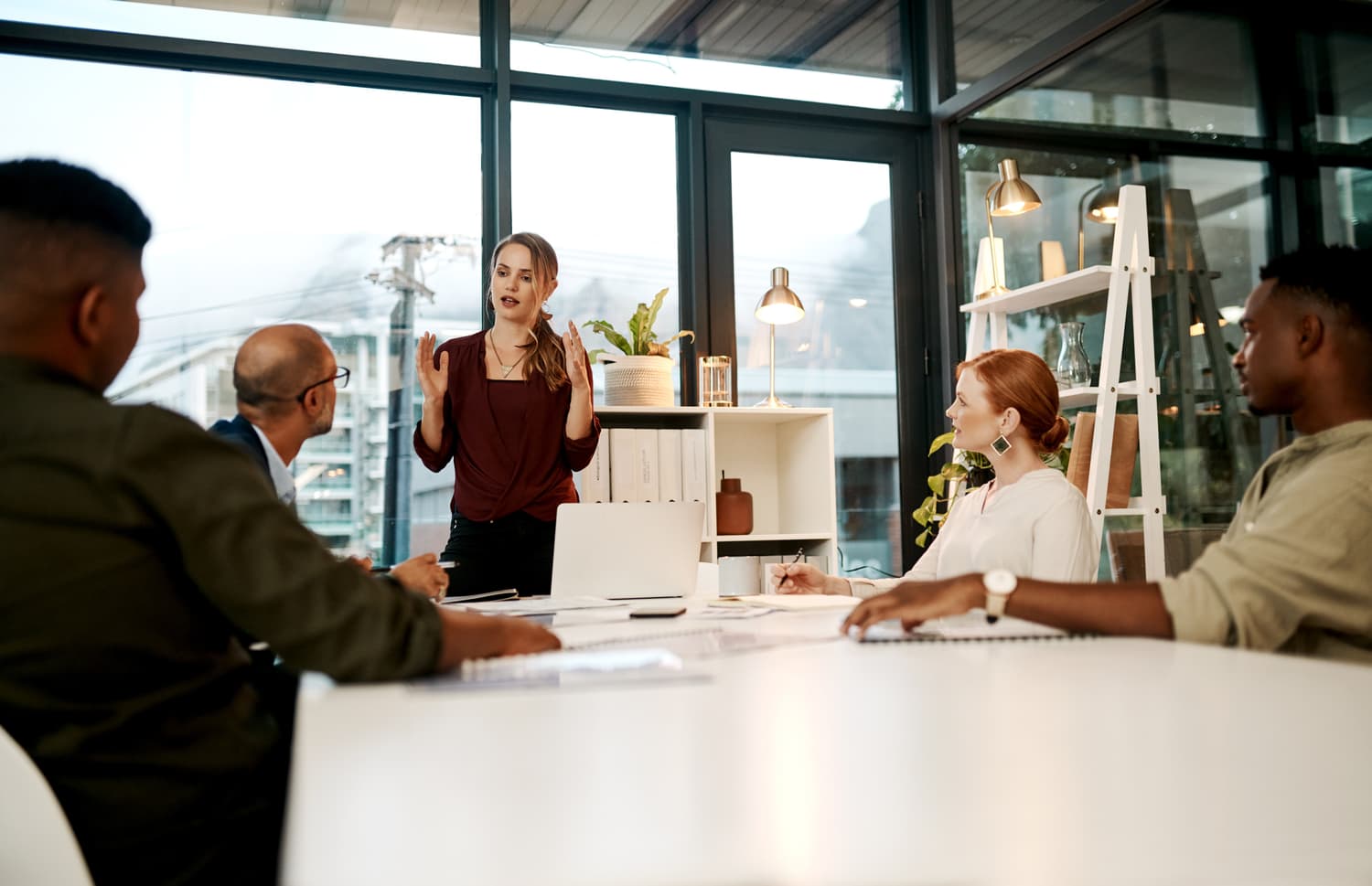 Presenter addressing a seated group in a boardroom